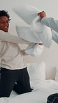Energy, pillow fight and playing with African boy in bedroom for bonding or family fun on holiday. Break, father and happy son on bed in home for affection, cheerful activity or playful love