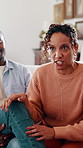 Couple, stress and discussion on sofa for counseling, explain crisis and relationship strain. Mature woman, african people and frustrated in therapy session with consultation for conflict resolution