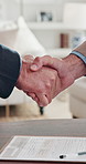 Real estate, offer or handshake in house with contract, sale acceptance or deal closing in meeting. Partnership, men or realtors with shaking hands, home transfer or success in investment negotiation