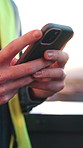 Cellphone, man and hands of construction worker in city with texting, typing or email on feedback. Technology, chatting and civil engineer with phone for communication on building approval in town.