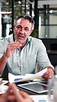 Business, meeting and man with document in office for campaign planning, KPI review or feedback. Marketing team, mature manager and graphs for web traffic data, competitor analysis and sales report