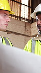 Blueprint, meeting and men in workshop for construction material, renovation project or collaboration. Talking, team and people with documents, remodeling design and planning with building contractor