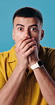 Man, studio and face with shock for bad news, disappointment or disbelief on a blue background. Portrait, male person or surprise with mouth covered or notification for no, rejection or disapproval