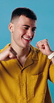 Man, excited and dance with music in studio for fun, energy and happiness. Smile, celebration and dancer person with streaming, hip hop or listen to audio subscription on blue background to relax