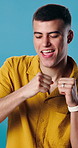 Man, smile and dance with music in studio for fun, energy and happiness. Excited, celebration and dancer person with streaming, hip hop or listen to audio subscription on blue background to relax