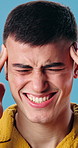 Headache, stress and man in studio with vertigo, pressure or brain fog for university scholarship. Temple massage, tinnitus and student with migraine for college fail or burnout by blue background.