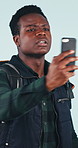 Travel, phone or black man with bad signal for lost direction or navigation on a studio background. Traveler, confused or male person with smartphone for mobile reception, network connection or app