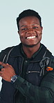 Happy, face and black man pointing in studio for adventure advice or tips on a blue background. Portrait, male person or traveler with smile or backpack for advertising or marketing travel app
