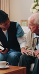 Bible, faith and caregiver with senior man, talking and worship with scripture and spiritual belief. Assisted living, home and old person with book for religion, knowledge and Jesus Christ guidance