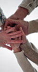 People, meeting and hands together in studio with unity for solidarity below on a white background. Low angle, group or community piling with stack for synergy, social cohesion or inclusion on space