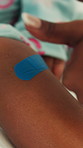 Hands, thumbs up and child with plaster for injury, parent or first aid approval for knee protection. Healing, wound and person with kid, support and leg bandage after accident, healthcare and help