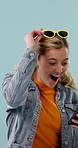 Sunglasses, phone and woman in studio with shock for fashion sale, discount and deal on website. Happy, omg and person on cellphone for retail news, notification and online bargain on blue background