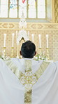 Back, priest and man in church with worship, Christian religion and prayer for connection to God. Catholic bishop, person and praise Jesus Christ in chapel with belief, faith and hope for salvation.