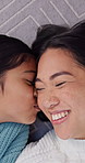 Kiss, above and child with mom on floor for bonding, connection and loving relationship in home. Portrait, happy and girl with mother for affection, trust and laugh together for family weekend
