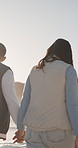 Travel, holding hands and walk with couple at beach for romantic getaway, vacation and connection. Anniversary holiday, tropical adventure and love with man and woman outdoor for date and trust