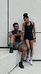 Fitness, couple and smile with phone in city for rest, check timer or laugh with results conversation. Runners, black man and woman with mobile on steps for meme, tracking progress or exercise break