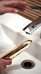 Water, sink and hands of person with sex toy for hygiene, germ prevention and maintenance. Bathroom, home and woman with facet, cleaning and sensual accessory for wellness, washing and disinfection