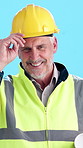 Man, face and architect in studio with hardhat, safety protocol or compliance requirements. Smile, mature engineer and helmet on blue background for building development, project management and plans