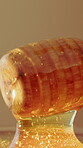 Health, dipper and honey in studio for nutrition, antibacterial properties and natural sugar. Raw, organic sweetener and stick on brown background for syrup additive, antioxidants and gut wellness