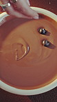Above, hands and chocolate pudding with blueberries for mousse dessert, garnish and sweet treat. Fruit, person and creamy cocoa for homemade recipe process, presentation and decadent snack in home