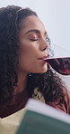 Red wine, reflection and woman with book in home with relax, calm or satisfaction on weekend. Novel, thinking and person drinking alcohol beverage for peace, nostalgia or positive attitude in house.