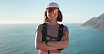 Happy, hiking and face of woman outdoor by ocean for discovery, adventure or exercise on holiday. Smile, sunglasses and portrait of female person in nature for trekking by sea for active on vacation.