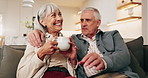 Smile, old couple and relax in home with coffee, love and support for bonding together on sofa. Senior people, rest or beverage on couch with embrace, partner affection and comfortable for retirement