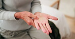 Home, hands and senior woman with wrist pain for arthritis, nerve compression and inflammation. Retirement, elderly person and muscle massage on bed with discomfort, rheumatism risk and osteoporosis