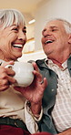 Tea, talk and senior couple with laugh in home for funny story, healthy marriage or connection. Love, happy people or conversation with drink in house for bonding together, retirement support or joke