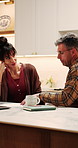 Couple, finance and documents with laptop in kitchen for mortgage payments, bills or investment. Mature man, woman and discussion with paperwork on computer for financial planning or invoices in home