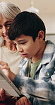 Smile, grandma and child at house with tablet, browsing and download ebook for education. Happy, senior woman and kid in lounge with digital, watching video and educational games for online learning