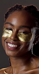 Beauty, eye mask and face of black woman in studio for hydration treatment or satisfaction. Gel patches, glow  and shine with happy person on dark background for collagen, skincare or vitamin c