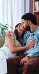 Kiss, couple and love on sofa with smile, bonding and gossip in living room. Embrace, happy man and woman with communication in house for relationship, relax or weekend in home lounge with support