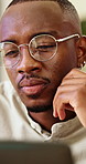 Reading, glasses and black man in office with laptop for company compliance, policy or thinking. Spectacles, problem solving and consultant with tech, planning or review for financial regulation