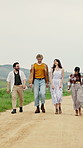 Happy, friends and walking together in countryside for travel, outdoor adventure or journey. People, group or travelers on dirt road, trail or path for weekend getaway, holiday or trip in nature