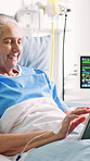Senior, patient and happy woman with tablet in hospital bed for online connection or social media. Elderly, female person or scrolling with smile on technology for internet, network or app in clinic 