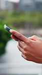 Person, hands and typing with phone in city for communication, outdoor network or connection. Closeup, user or texting with mobile smartphone for online chatting, app or research in an urban town