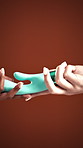 Sensual, giving and hands of people in studio for pleasure, personal intimacy and self care. Passion, share and women with accessory for sex education, wellness and stimulation on red background