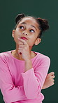 Curious, child and girl in studio with thinking, contemplation and wonder for childhood development. Kid, idea and problem solving with thoughts, planning and vision for future on green background.