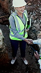 Construction, meeting and people with handshake outdoor for agreement, collaboration and planning. Civil engineering, above and workers shaking hands for site approval, partnership and renovation