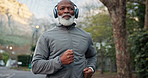 Black man, running and headphones at park for fitness, exercise and streaming podcast on retirement. Happy, senior person and runner in nature with playlist, listening to music and physical activity