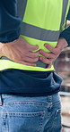 Hands, back pain and person on construction site with injury, arthritis or accident and inflammation. Contractor, fibromyalgia or civil engineer at workplace with joint ache, tension or muscle sprain