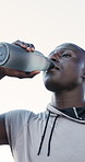 Fitness, drink and black man with water in nature for hydration, vitamins or outdoor nutrition. Active, male person or runner with mineral liquid or beverage for workout break, rest or recovery