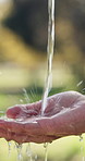 Water, nature and person washing hands outdoor for hygiene, health or self care in countryside. Sustainability, organic and liquid for cleaning skin for dirt, germs or bacteria removal on farm.