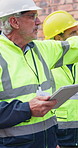 People, talk and tablet at site for construction, research and inspection report for architecture. Mature men, walk and review at worksite with digital, maintenance checklist and building development