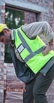 Architect, man and pain with back injury on construction site for overworked pressure or discomfort. Mature, male person or civil engineer with sore spine for building accident, fall or fibromyalgia