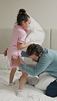 Dad, bed and pillow fight with child for fun bonding, playing or weekend together in home. Father, playful kid or daughter with love, care or childhood for holiday, break or funny game in bedroom