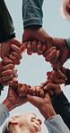Blue sky, people and hands together with circle for fitness, support and health celebration. Nature, teamwork and personal trainer with huddle for solidarity, exercise goal or motivation in low angle