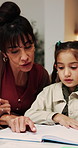 Mom, child and teaching with book in home for education, homework or tutoring daughter. Mother, reading or kid with study notebook or learning for homeschooling or childhood development in house