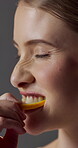 Skincare, orange or woman with bite, vitamin c benefit or nutrition in organic wellness. Diet, collagen or happy person on studio background with fruit, gut health or antioxidant in natural cosmetics